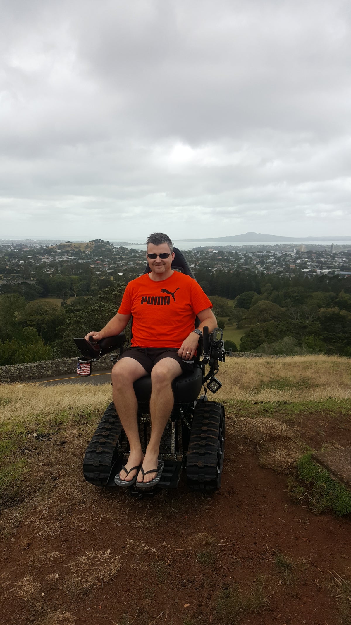 A TracFab rider at a hilltop overlook above a town and coastline.