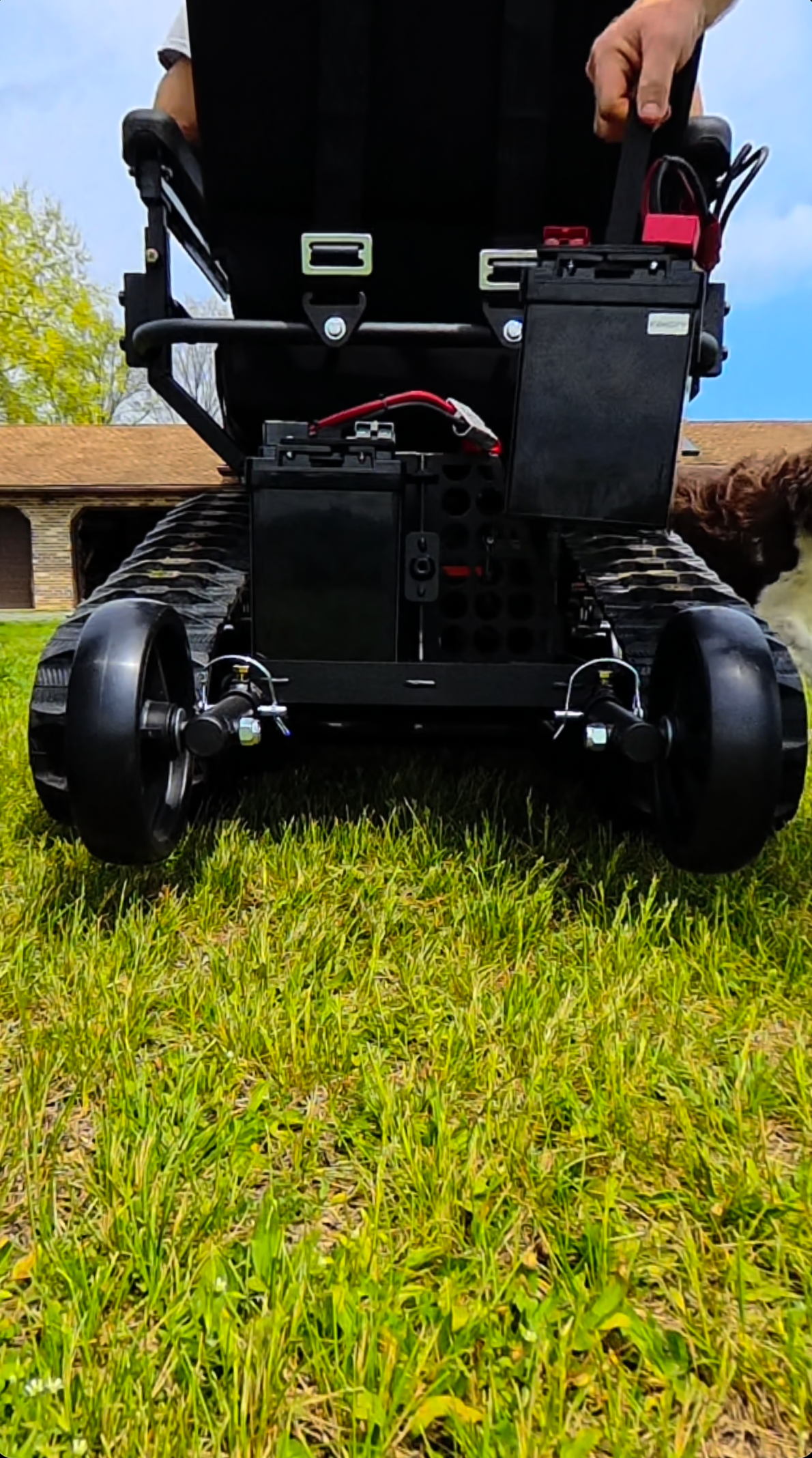 A removable TracFab lithium battery being lifted by its handle while the second battery remains installed.